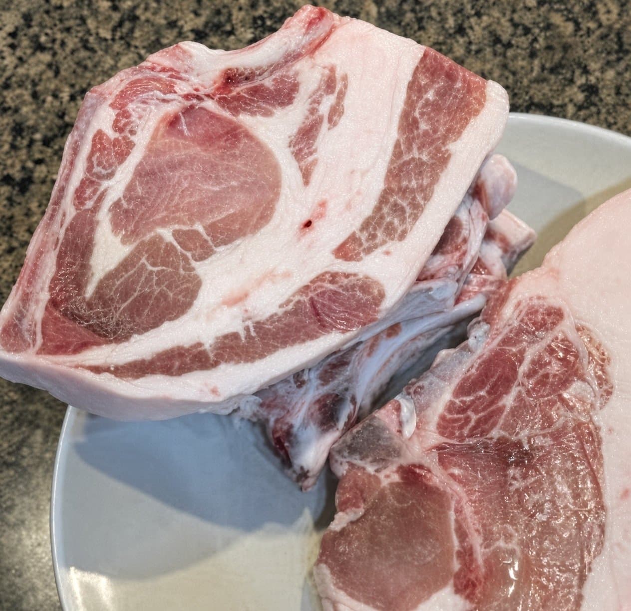 Thick-cut pork chops from our pigs, red meat with marbled fat